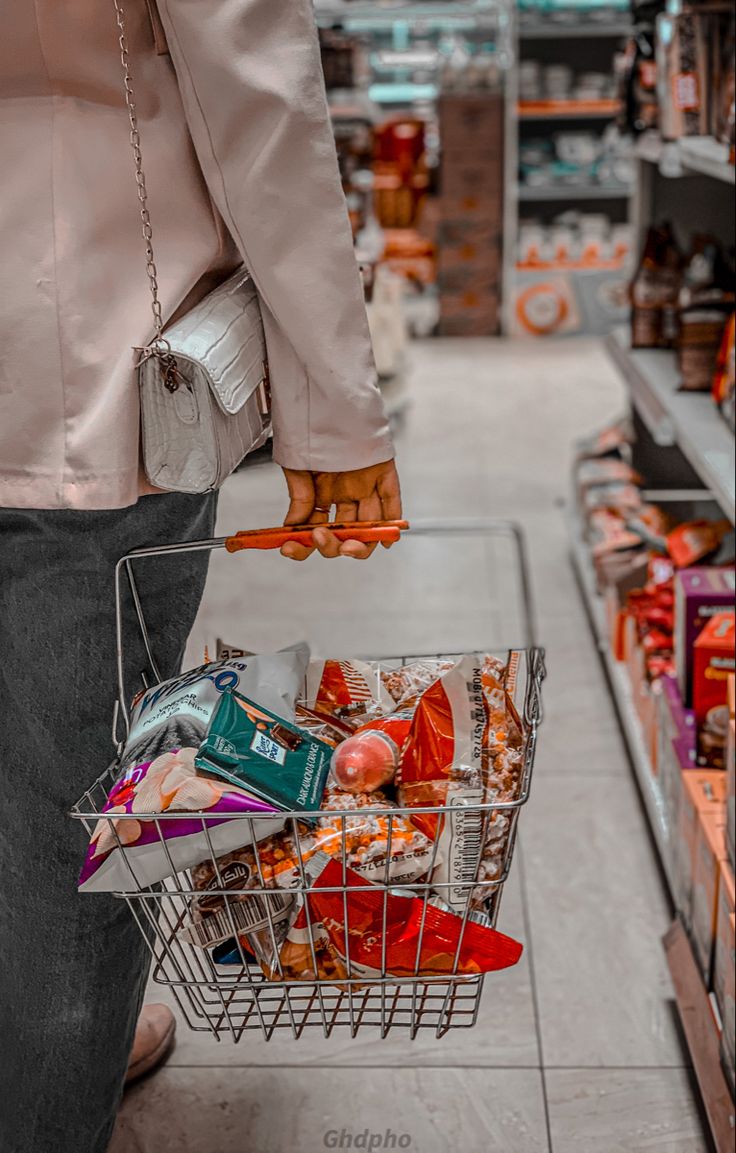 Mulher segurando uma cesta de supermercado com ingredientes