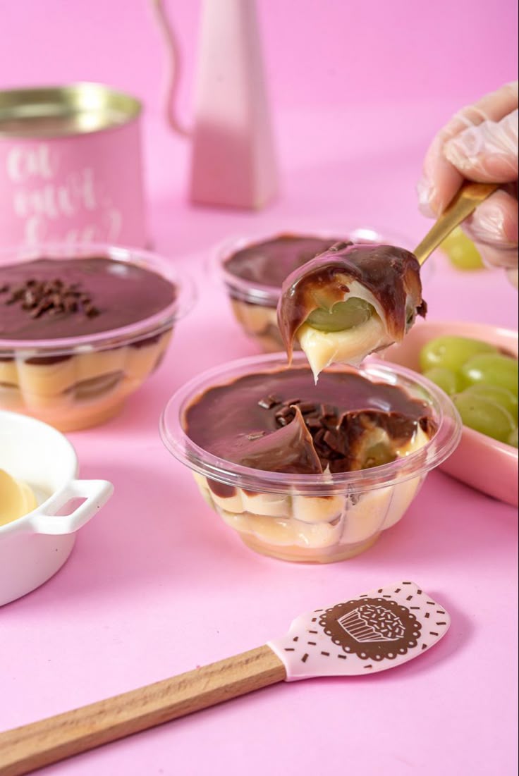 Bombom no pote com chocolate e uvas sobre fundo rosé